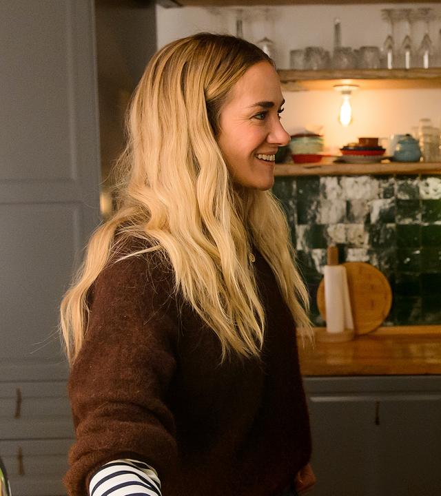 Betty (Annina Hellenthal) und ihre Mutter Gabriele (Nina Petri) stehen sich in Bettys Küche gegenüber. Gabriele hält ein Glas Wein und lächelt Betty an, die glücklich zurück lächelt.