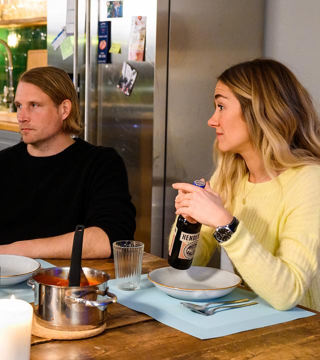 Yannick Weiss (Alvar Goetze), Oliver Weiss (Alexander Koll) und Betty Weiss (Annina Hellenthal) sitzen in Bettys Küche am gedeckten Esstisch. Betty und Oliver schauen Yannik erwartungsvoll an.