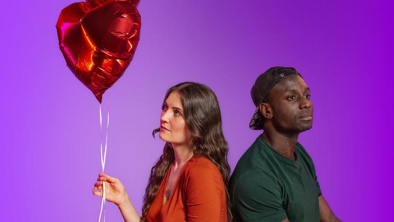 Frau und Mann sitzen mit Rücken zueinander und halten Luftballons in der Hand