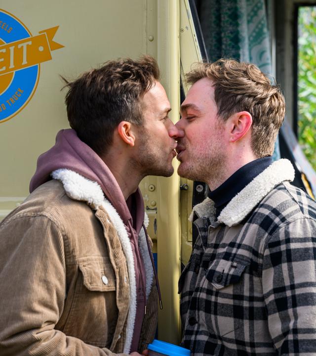 "Bettys Diagnose - Beziehungsprobleme": Dr. Paul Eckart (Florian Frowein) und Ron Berger (Moritz von Zeddelmann) geben sich am Kioskwagen einen Kuss.