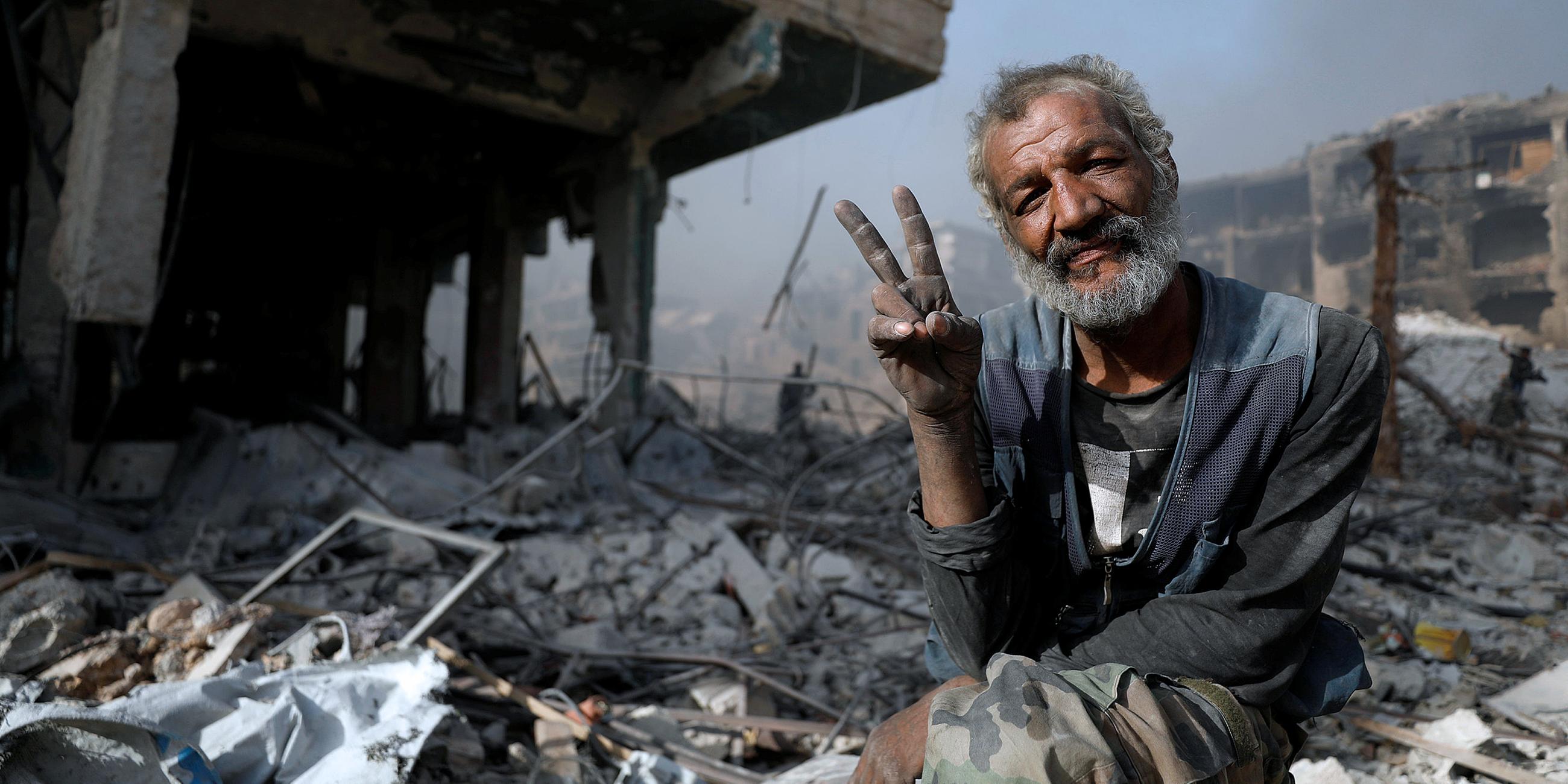 Archiv: Ein Mann zwischen den Trümmern eines zerstörten Gebäudes in Syrien, aufgenommen am 21.05.2018  in Al-Hajar Al-Aswad