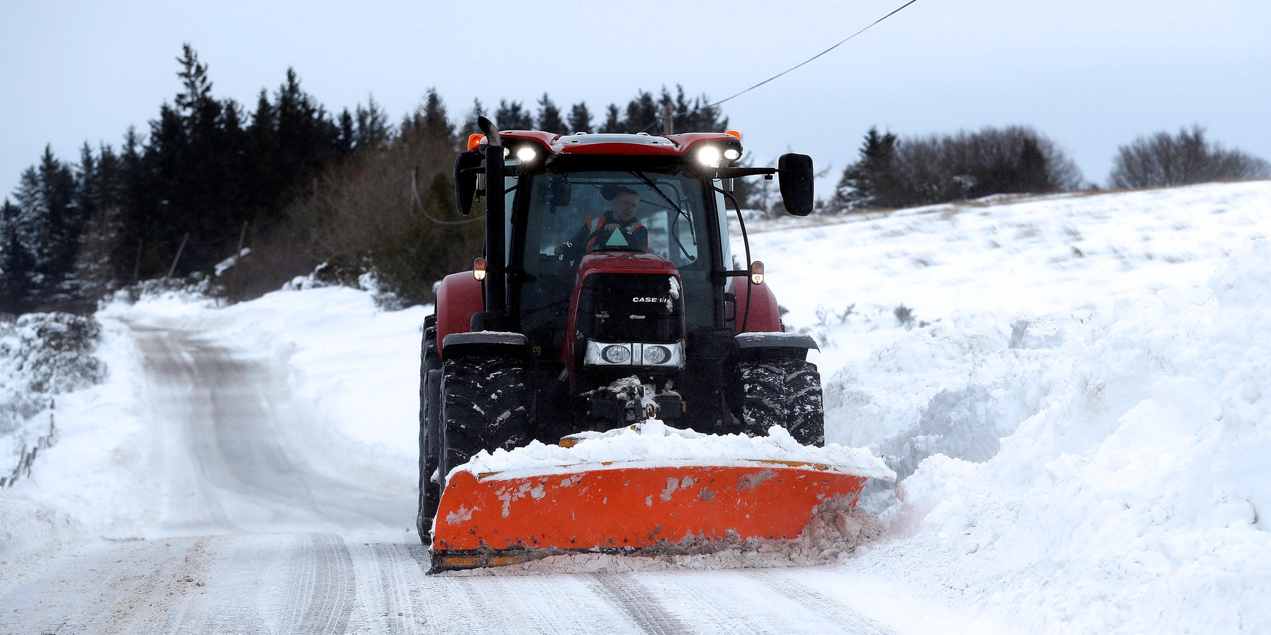 Ein Traktor räumt eine verschneite Straße in Schottland, aufgenommen am 02.03.2018