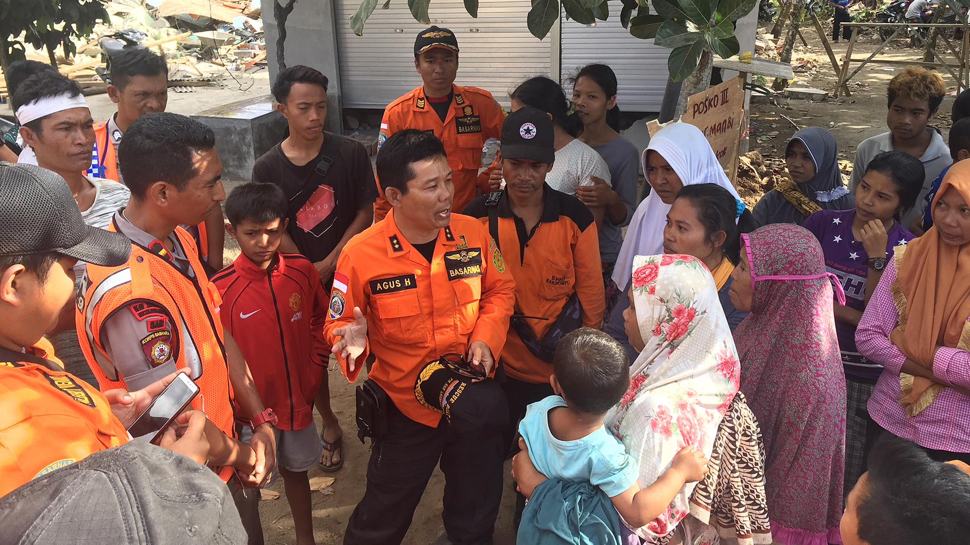 Agus, Chef der Rettungskräfte, informiert in Rempek (Indonesien) Angehörige über die Suche nach den Vermissten, aufgenommen am 12.08.2018