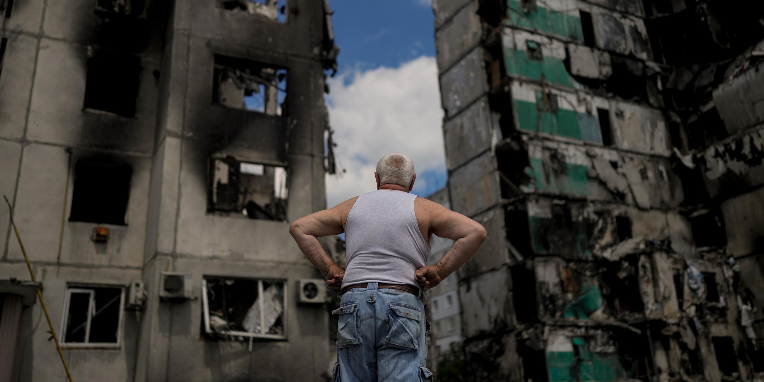 Ein Mann betrachtet Gebäude, die bei russischen Angriffen auf Borodyanka am Stadtrand von Kiew zerstört wurden, aufgenommen am 04.06.2022 in Kiew