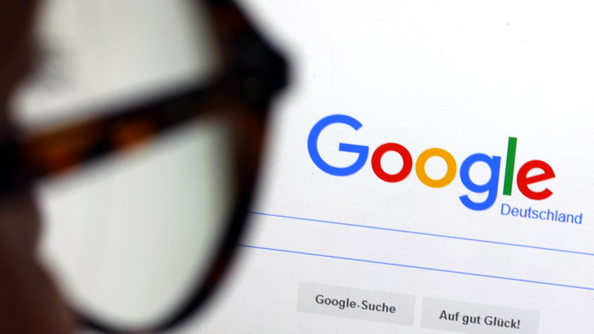 Illustration: Die Seite der Suchmaschine von Google ist hinter einer Frau mit Brille zu sehen, aufgenommen am 07.12.2022