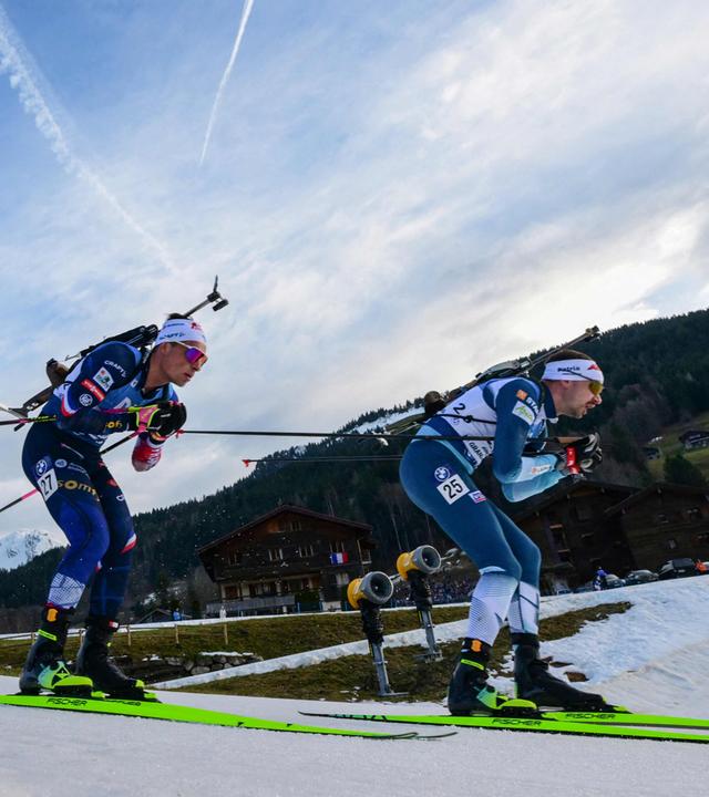 Finnlands Olli Hiidensalo (r.) und Frankreichs Oscar Lombardot (M.) im Wettkampf beim 15-km-Massenstart der Männer im IBU Biathlon-Weltcup.