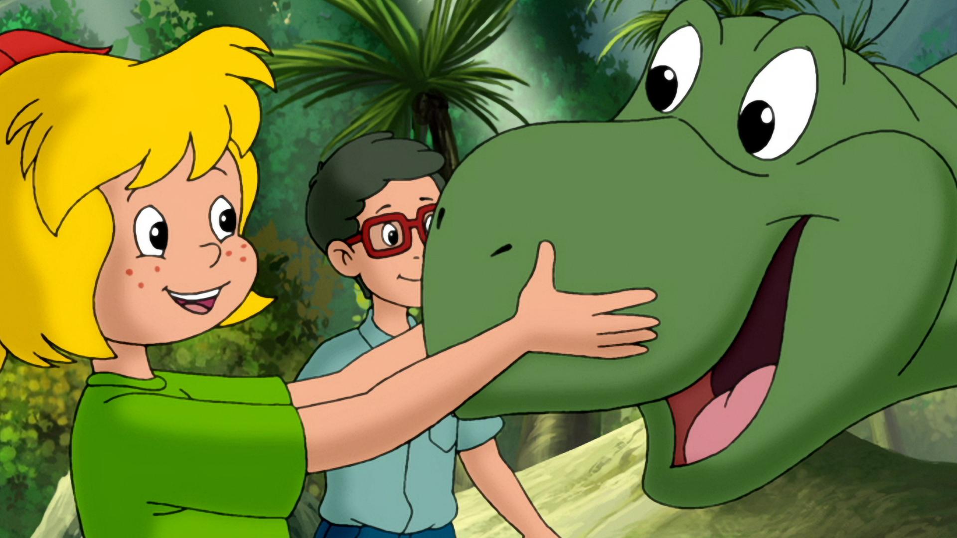 Bibi und Florian streicheln einen jungen grünen Dinosaurier.