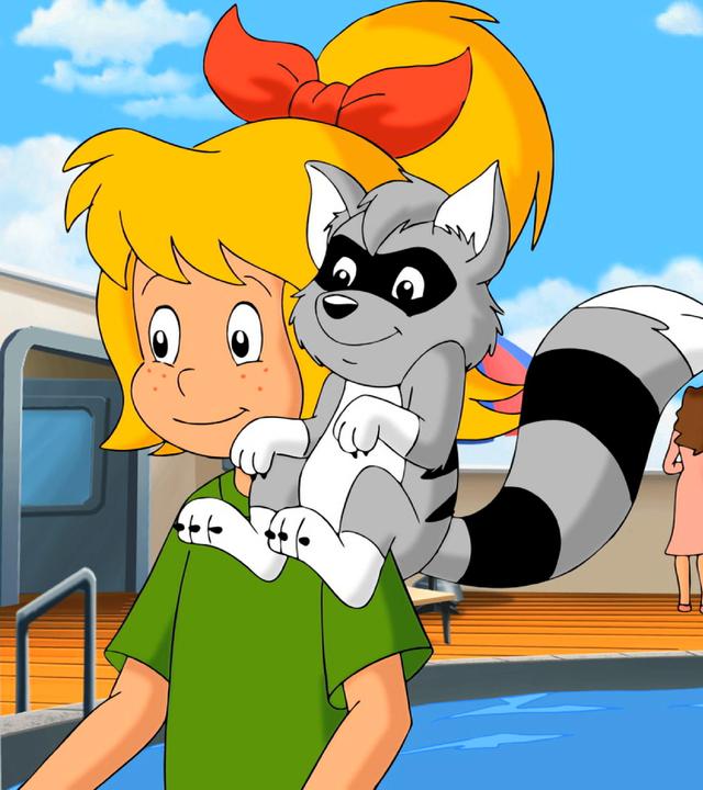 Bibi hat den Waschbären Freddy auf ihrer Schulter. Im Hintergrund ist das Oberdeck eines Kreuzfahrtschiffes mit einem Pool zu sehen.