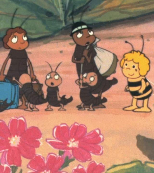 Zwei erwachsene Käfer mit Rucksack und Koffer wandern durch die Klatschmohnwiese und sind umgeben von ihren sechs kleinen Käferkindern. Bienenmädchen Maja spricht sie an.