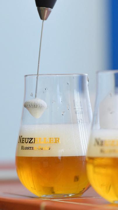 Zwei Gläser Pulverbier werden mit einem Aufschäumer zubereitet