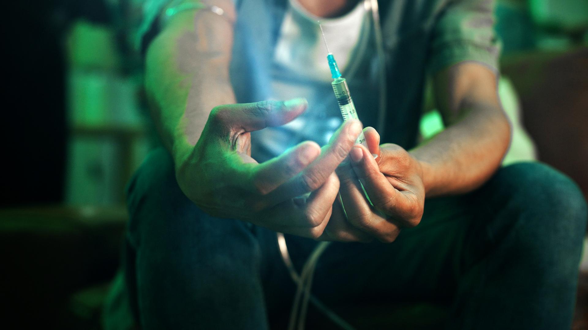 Ein Fixer hält eine Spritze mit Fentanyl in den Händen, Nahaufnahme