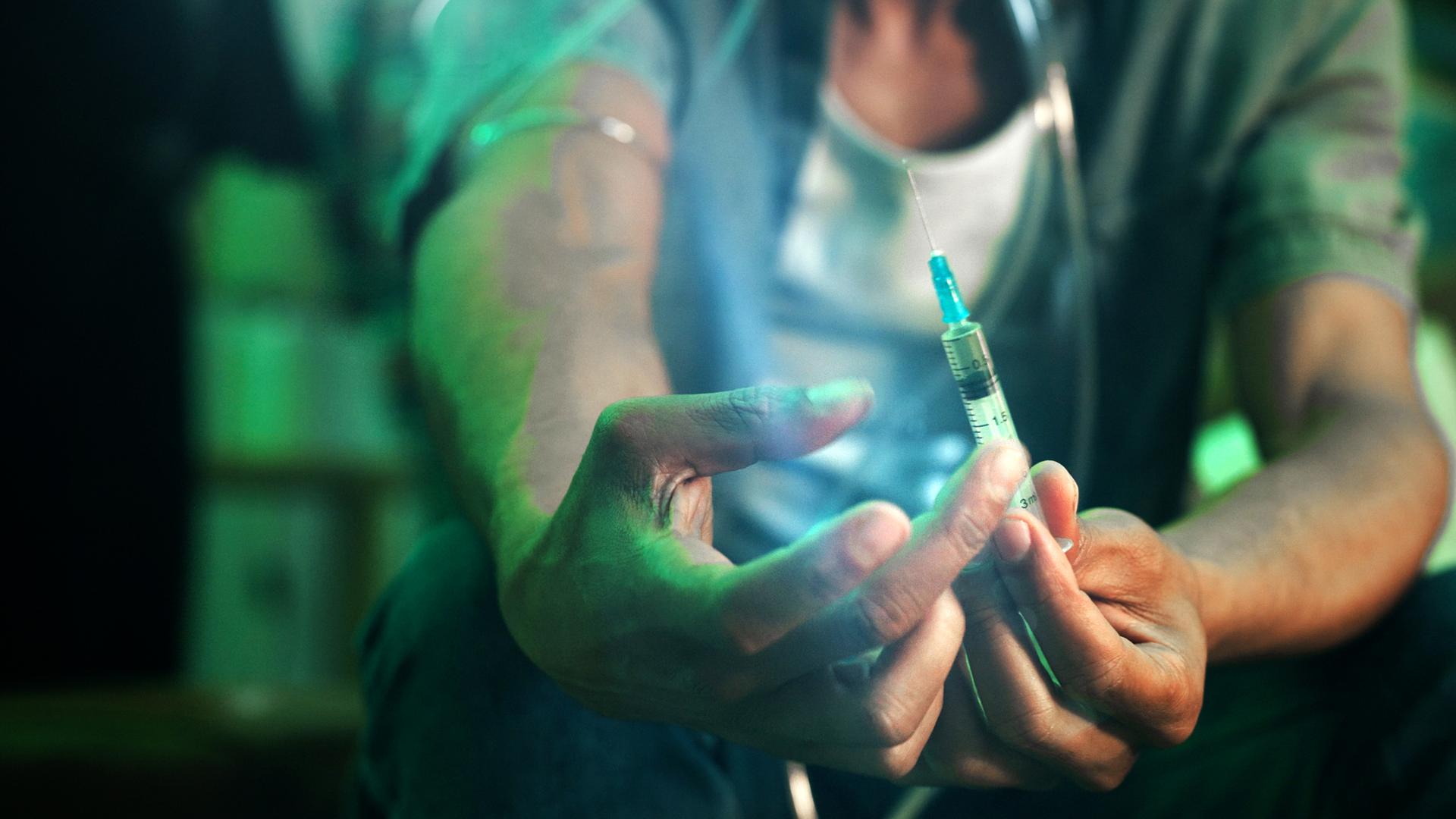Ein Fixer hält eine Spritze mit Fentanyl in den Händen, Nahaufnahme