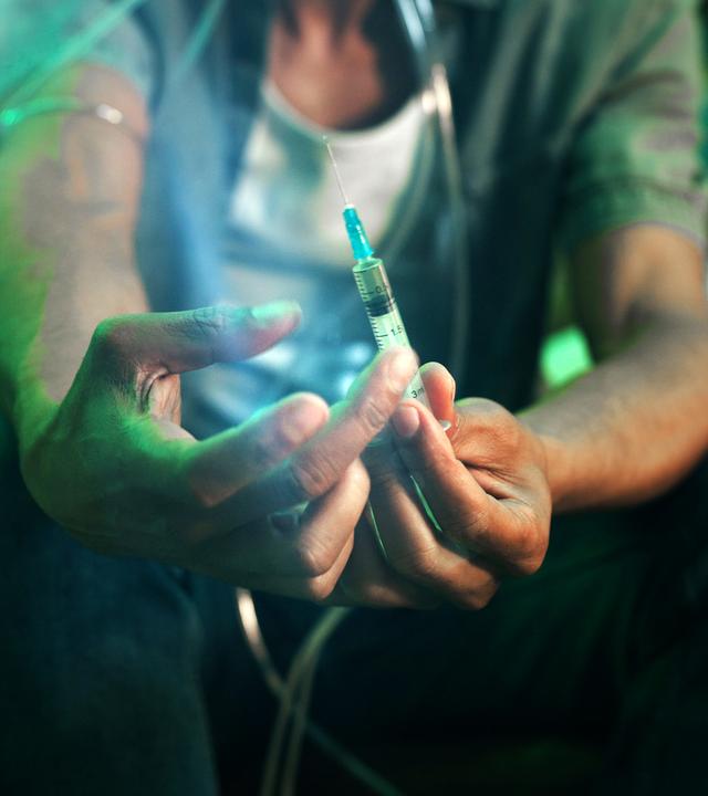 Ein Fixer hält eine Spritze mit Fentanyl in den Händen, Nahaufnahme