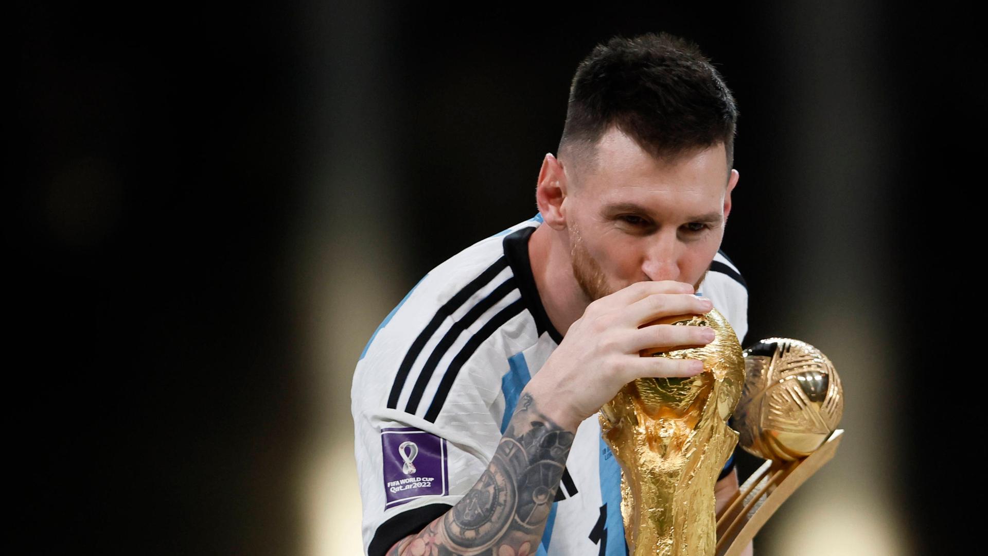 Lionel Messi streckt den WM-Pokal 2022 in die Höhe. 