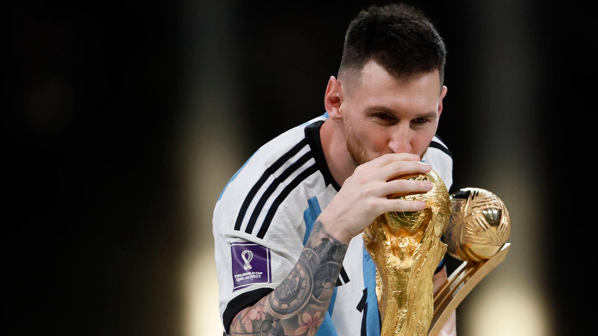 Lionel Messi streckt den WM-Pokal 2022 in die Höhe. 