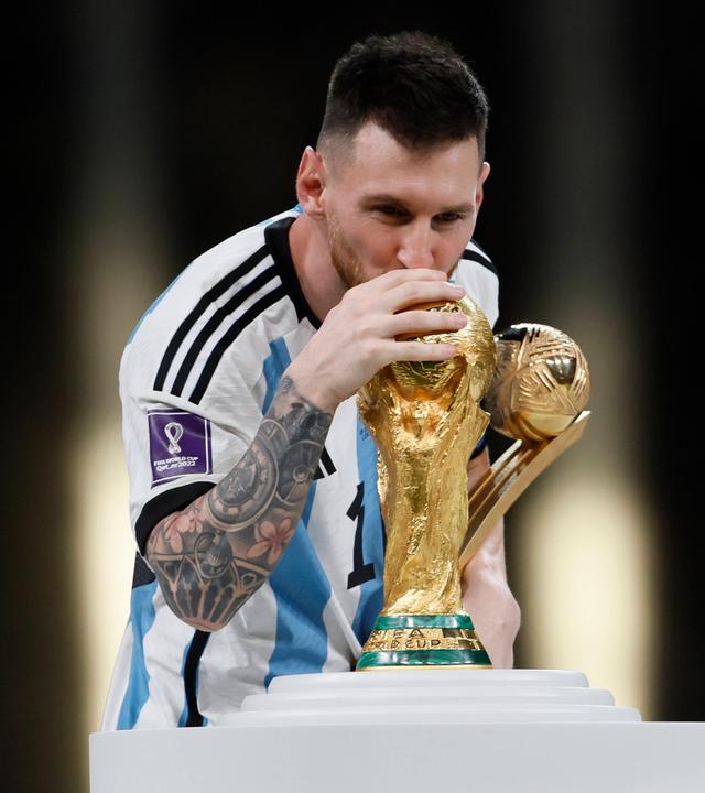 Lionel Messi streckt den WM-Pokal 2022 in die Höhe. 