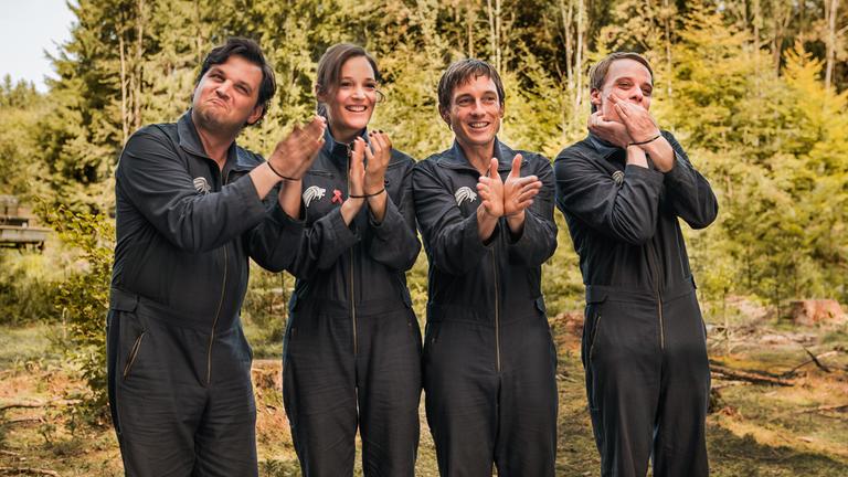 "Outside the Box": Kretsch (Sascha Alexander Gersak), von Geseke (Vicky Krieps), Schopner (Volker Bruch) und Grandier (Stefan Konarske) applaudieren mit gefesselten Händen zu einer vermeintlich inszenierten Geiselnahme.