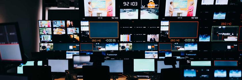 Dunkler Regieraum der ZDF-Regie mit in der Dunkelheit leuchtenden Bildschirmen.