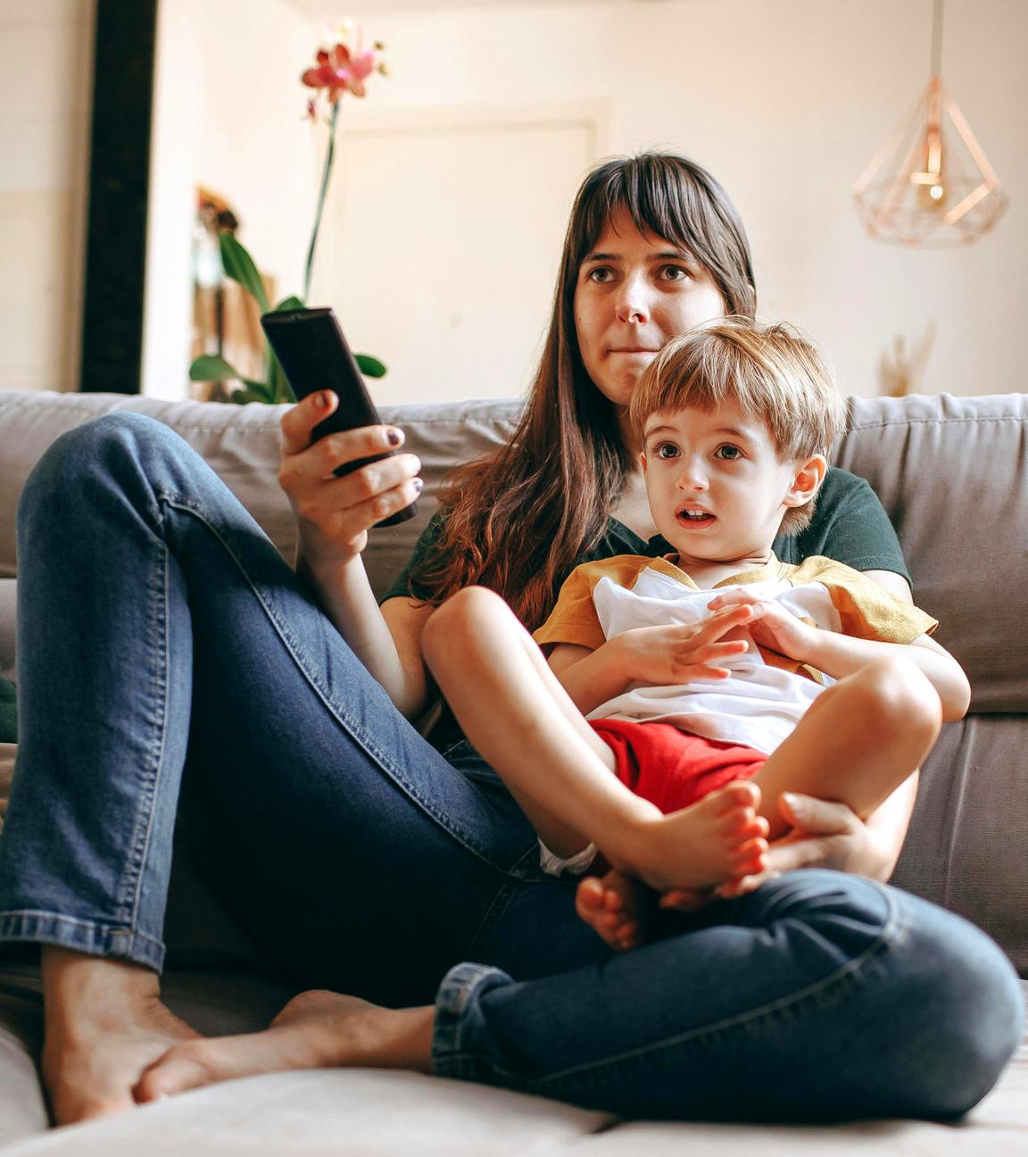 Typical Kinder- und Jeugendmedienschutz im ZDF: Mutter mit kleinem Kind im Schoss auf der Couch mit Fernbedienung