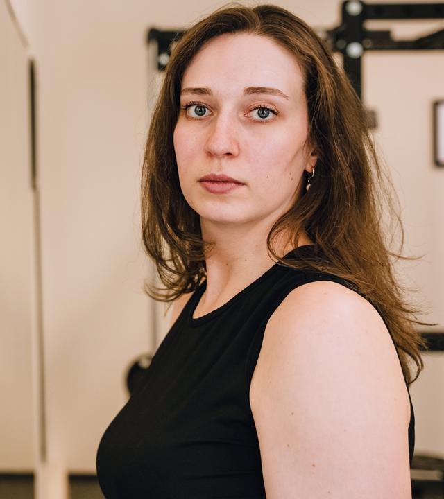 Junge Frau steht vor einem Spiegel und sieht verzweifelt aus.