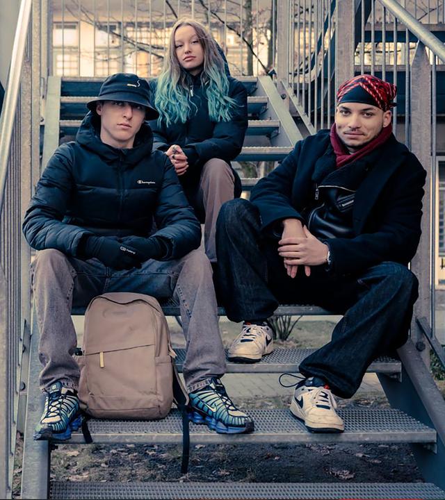 Drei junge Menschen schauen in die Kamera