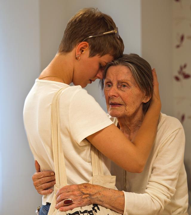 Oma Elvira mit Enkelin Luna umarmen sich. Luna legt ihre Stirn an die ihrer Oma.