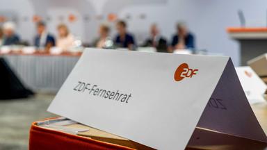 Tischschild mit Aufschrift ZDF-Fernsehrat, unscharfes Podium in Hintergrund