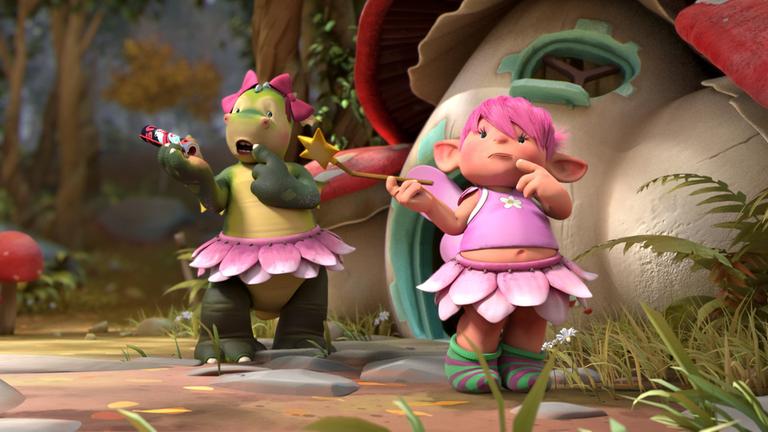"Drache Digby: Wer bin ich?": Digby, der Drache hat ein rosa Röckchen an und zwei rosa Schleifen am Kopf. In seiner rechten Pfote hält er sein Comicheft, den linken Zeigefinger hält er an seinen Mund. Fizzy, die Fee, steht mit ratlosem Blick vor ihm. In ihrer rechten Hand hält sie ihren Zauberstab. Den Zeigefinger ihrer linken Hand hält sie an ihren Mund.