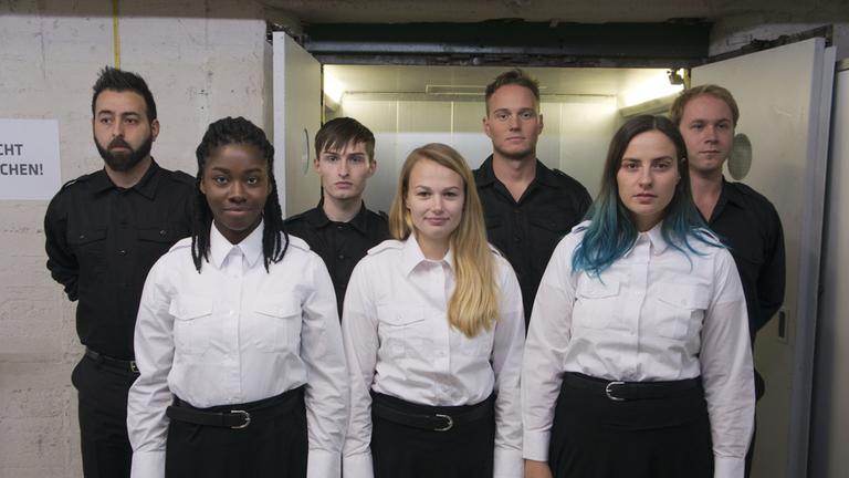 "Diktatur": Cihan, Matthias, André und Mirco sowie Nana, Naomi und Julia in Uniformen. Die Männer tragen schwarze Hemden und schwarze Hosen, die Frauen schwarze Röcke und weiße Blusen.