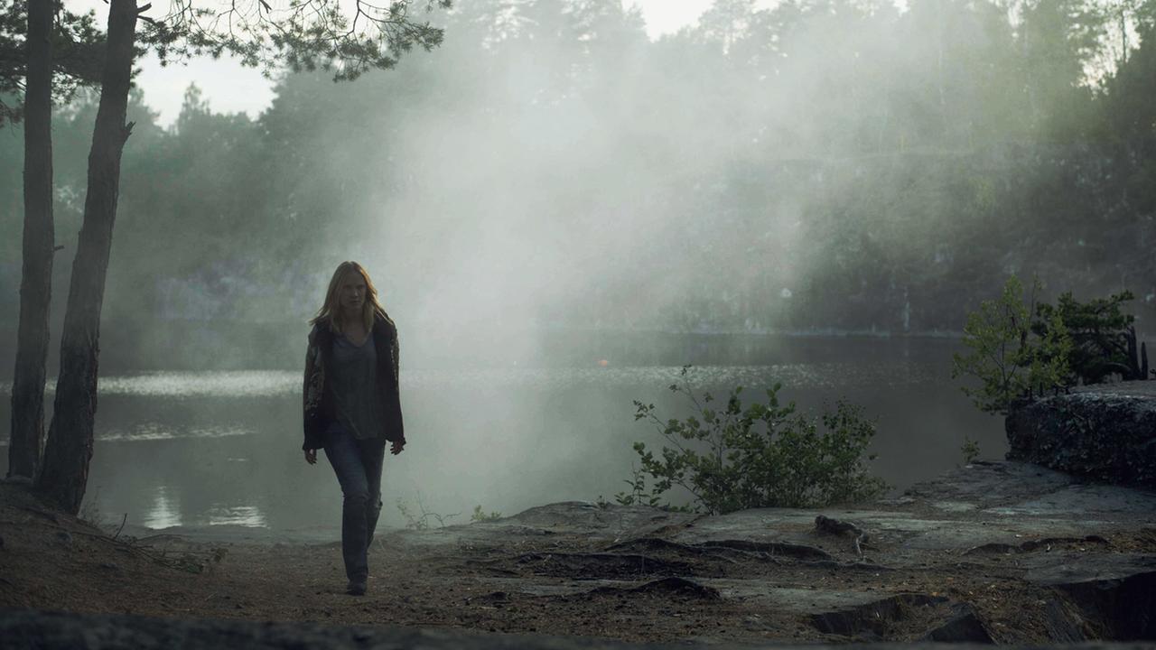 "Jordskott - Die Rache des Waldes - Teil 1": Eva Thörnblad (Moa Gammel) läuft alleine durch den Nebel am See.