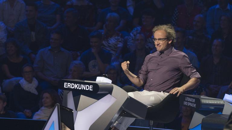 "Der Quiz-Champion": Wigald Boning sitzt am Pult vor Zuschauern im Studio.