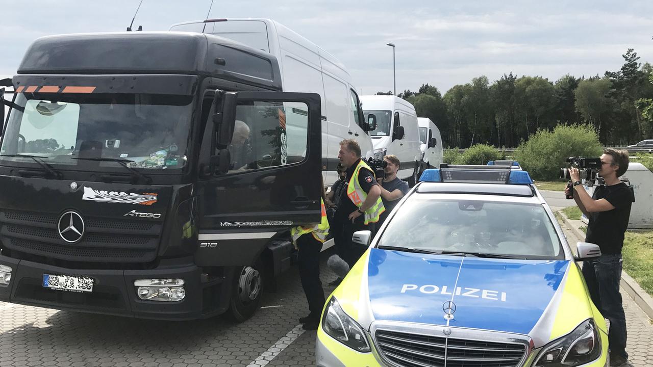 "ZDFzoom: Unter falschem Namen": Polizisten kontrollieren einen LKW.