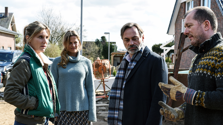 "Unter anderen Umständen – Das Geheimnis der Schwestern": Katharina Seidel (Nele Mueller-Stöfen), Sybille Barghaus (Janna Striebeck), Thomas Reuss (Peter Benedict) und Andreas Seidel (Martin Lindow) stehen vor einem Haus und sprechen miteinander.