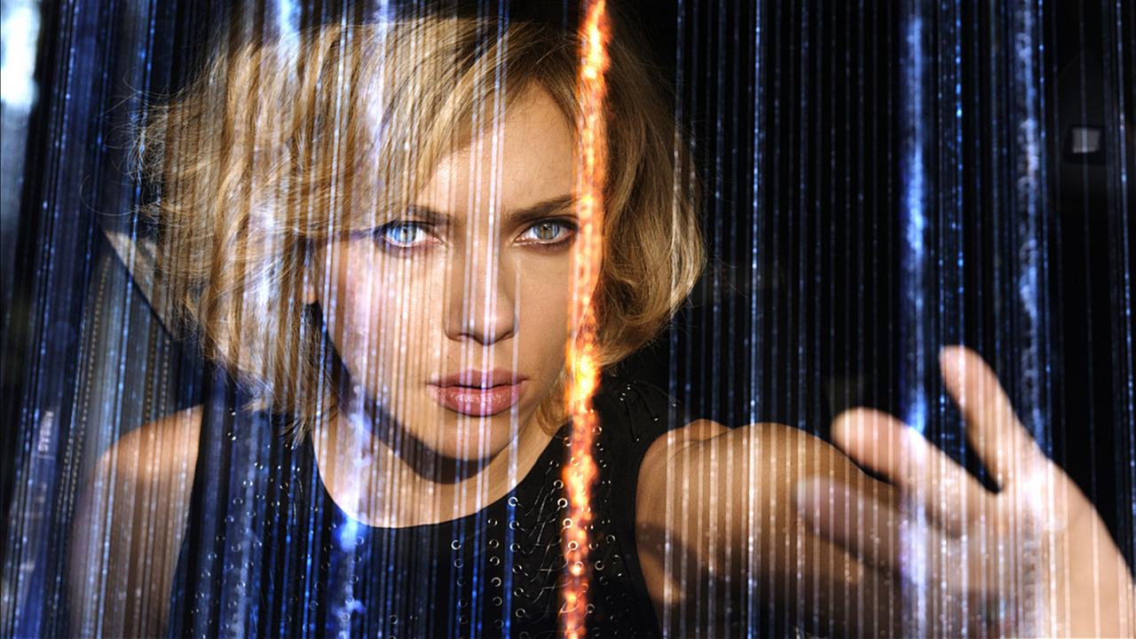 "Lucy": Lucy (Scarlett Johansson) greift in ein Netz aus leuchtenden, blauen Strängen.