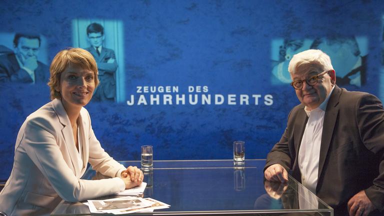 "Zeugen des Jahrhunderts: Joschka Fischer im Gespräch mit Marietta Slomka". Marietta Slomka und Joschka Fischer am Tisch sitzend.