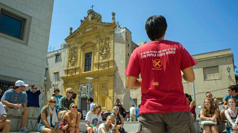 "Stolzes Sizilien": Ein Fremdenführer steht vor einer Gruppe Touristen.