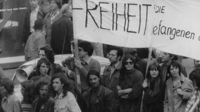 "Der Fall Susanne Albrecht: Die vielen Leben einer RAF-Terroristin": Demonstranten halten ein Transparent hoch.