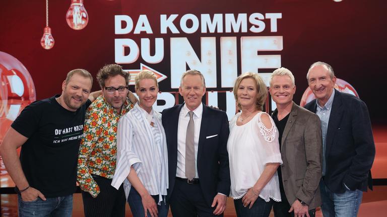 "Da kommst du nie drauf!": Auf dem Gruppenbild sind die prominenten Mitspieler und Moderator Johannes B. Kerner zu sehen: Mario Barth, Paul Panzer, Judith Rakers, Johannes B. Kerner, Suzanne von Borsody, Guido Cantz, Mike Krüger (v.l.n.r.). Im Hintergrund ist das Sendungslogo abgebildet.