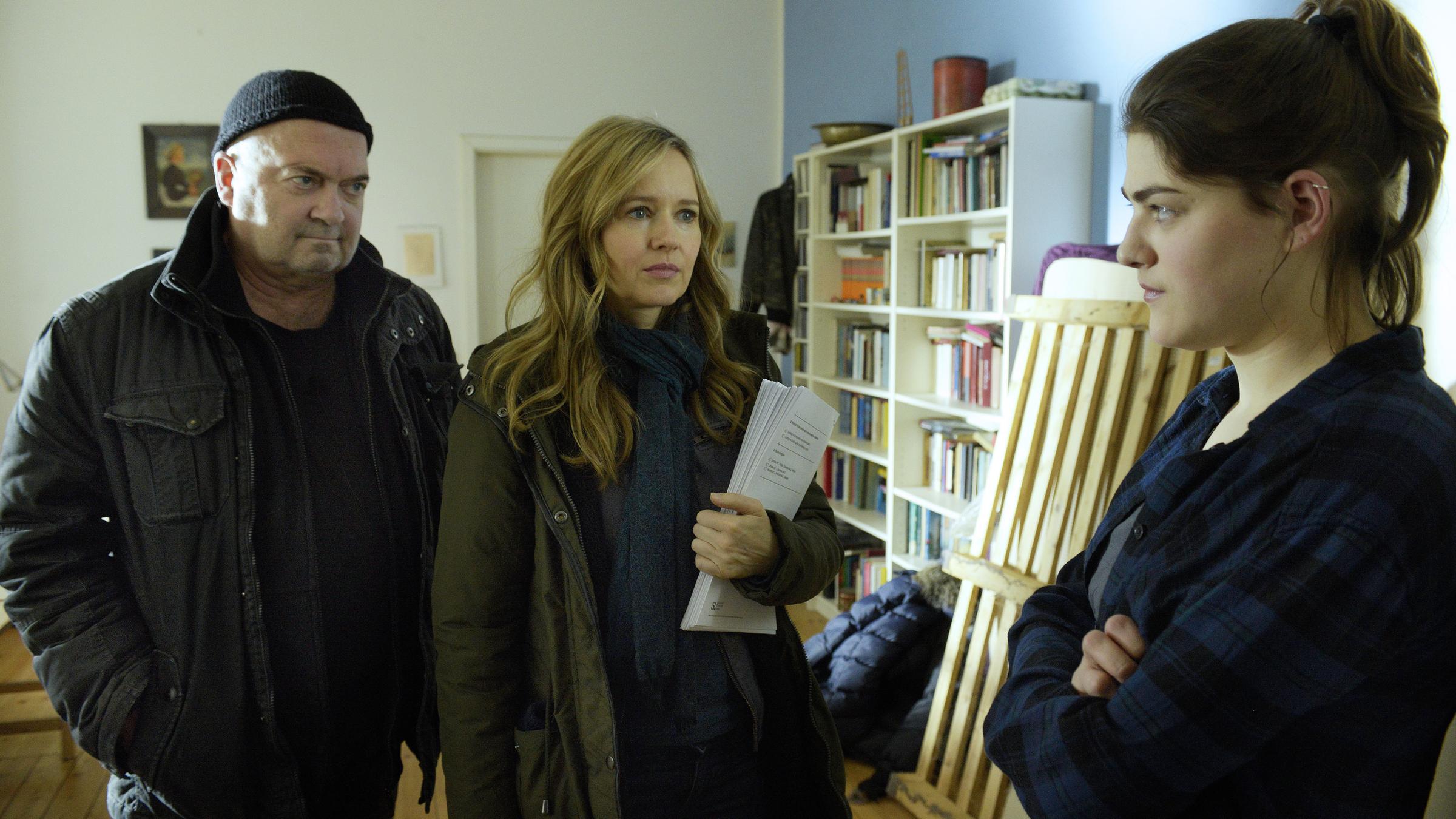 "Ein starkes Team - Tod einer Studentin": Otto Garber (Florian Martens), Linett Wachow (Stefanie Stappenbeck) und Claudia Viereg (Johanna Polley) stehen in Katjas Zimmer beisammen. Linett hält Papiere im Arm und schaut, ebenso wie Otto, zu Claudia, die mit verschränkten Armen vor ihnen steht.