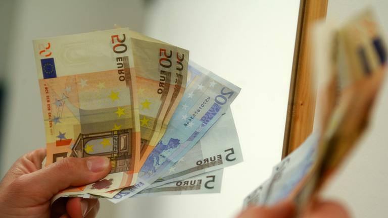 "Die sieben größten Fehler der EU": mehrere Euroscheine in den Händen einer Person.