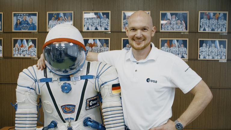 "Terra X - Erde - Mond-Mars" mit Alexander Gerst. Astronaut Alexander Gerst legt den Arm um einen Raumanzug.