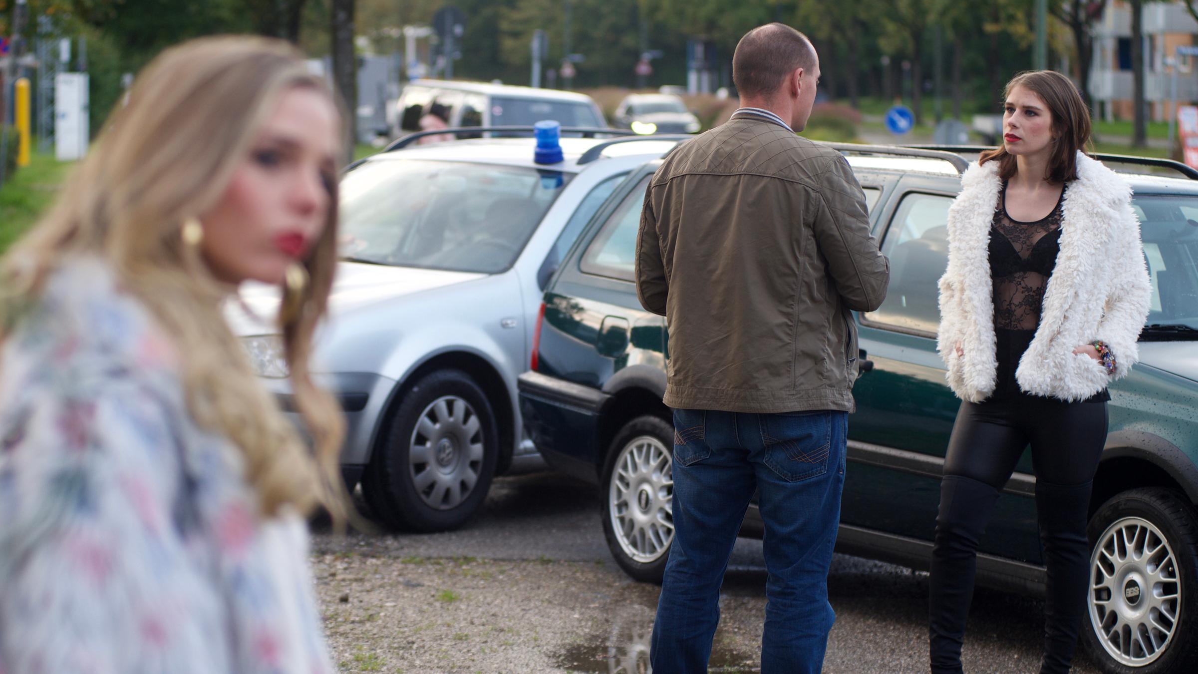 "Aktenzeichen XY... gelöst!": Eine Prostituierte spricht mit einem Polizisten in Zivil.  Im Vordergrund ist eine weitere Prostituierte zu sehen. Im Hintergrund sieht man zivile Polizeiautos mit Blaulicht.