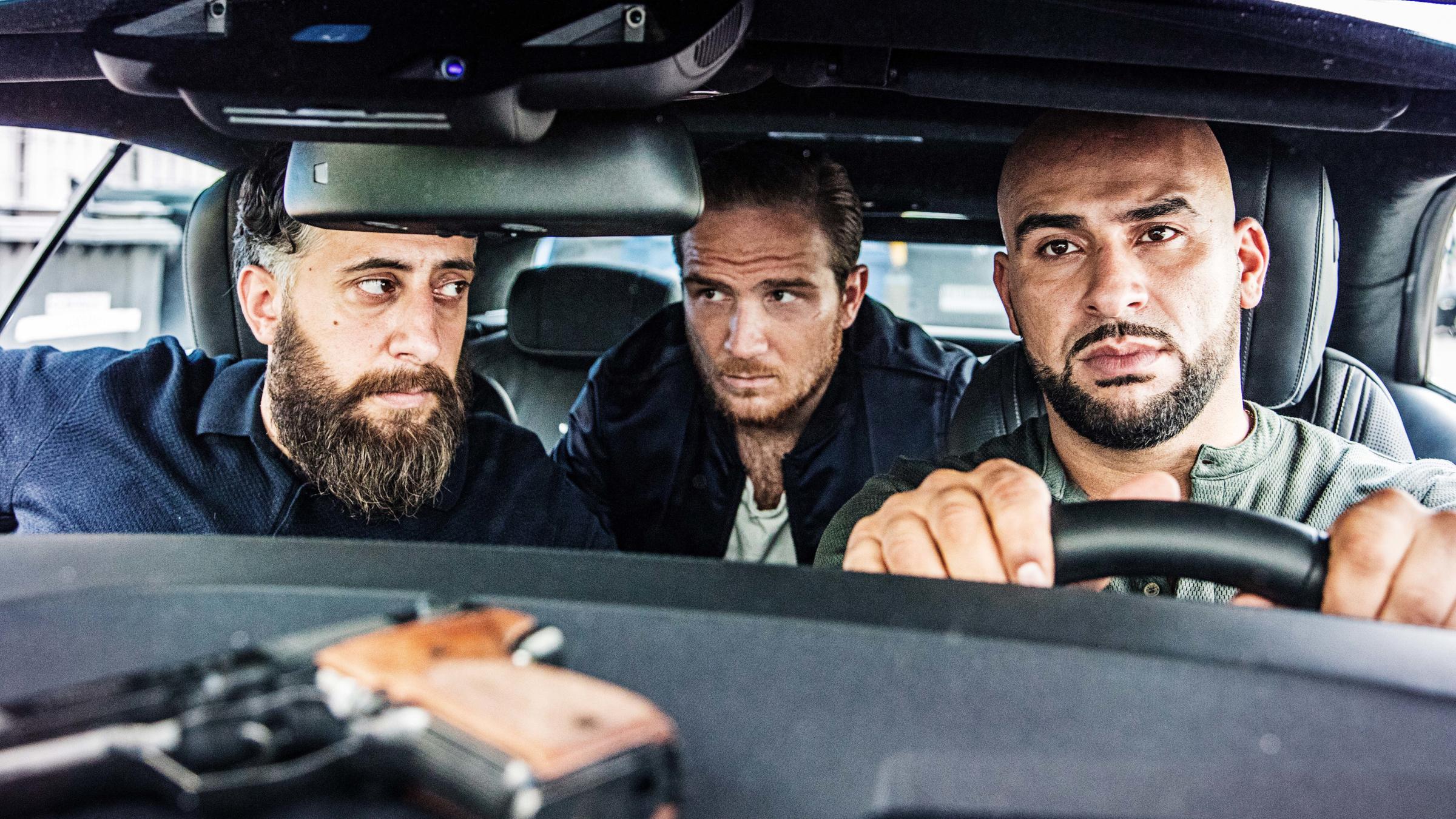 "4 Blocks - Brüder": Ali "Toni" Hamady (Kida Khodr Ramadan), Vince (Frederick Lau) und Abbas (Veysel Gelin) sitzen in einem Auto. Auf dem Armaturenbrett liegt eine Schusswaffe.