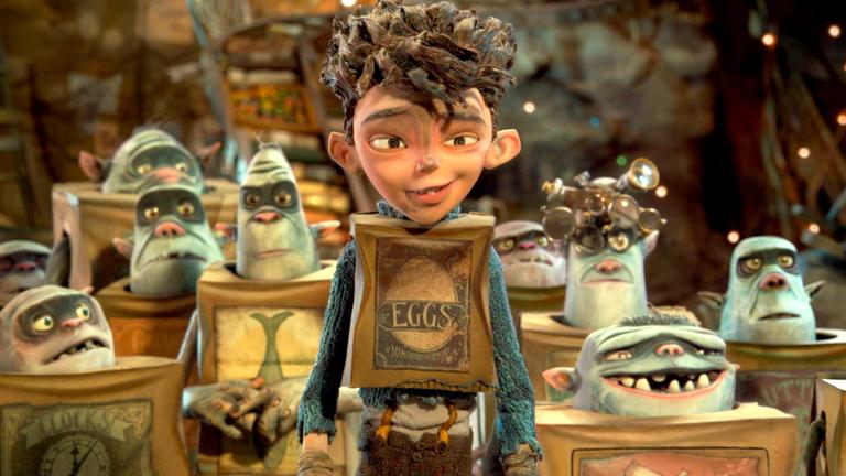  "Die Boxtrolls": Das Menschenkind Eggs steht zwischen den Trollen, die in Schachteln sitzen und ihre Köpfe herausstrecken.