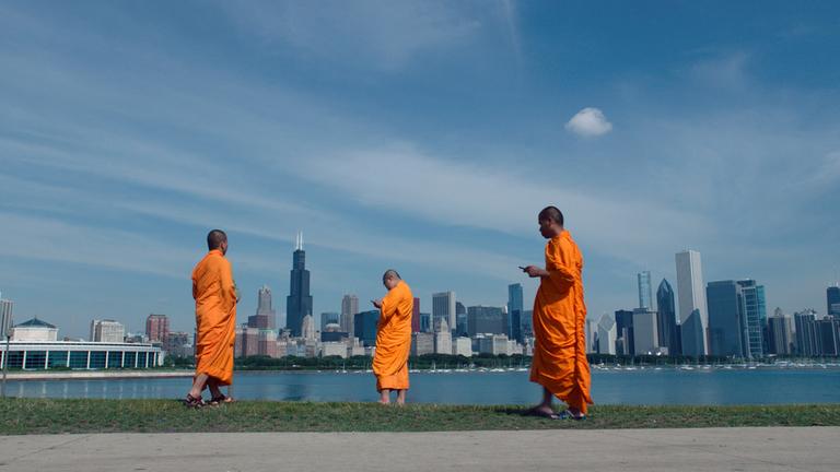 "Wovon träumt das Internet?" Buddhistische Mönche starren auf ihre Handys. Im Hintergrund die Skyline von New York.
