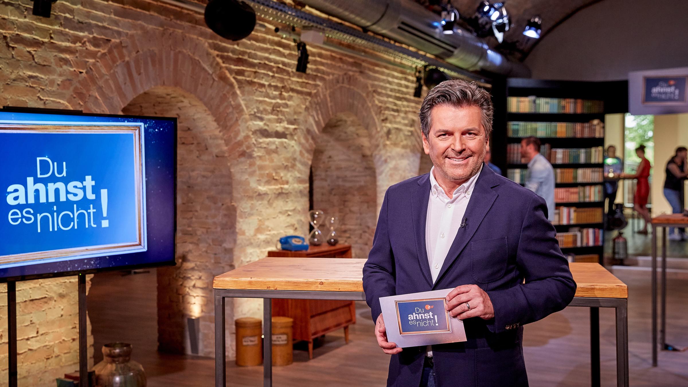 "Du ahnst es nicht!": Moderator Thomas Anders steht im Studio und lächelt.