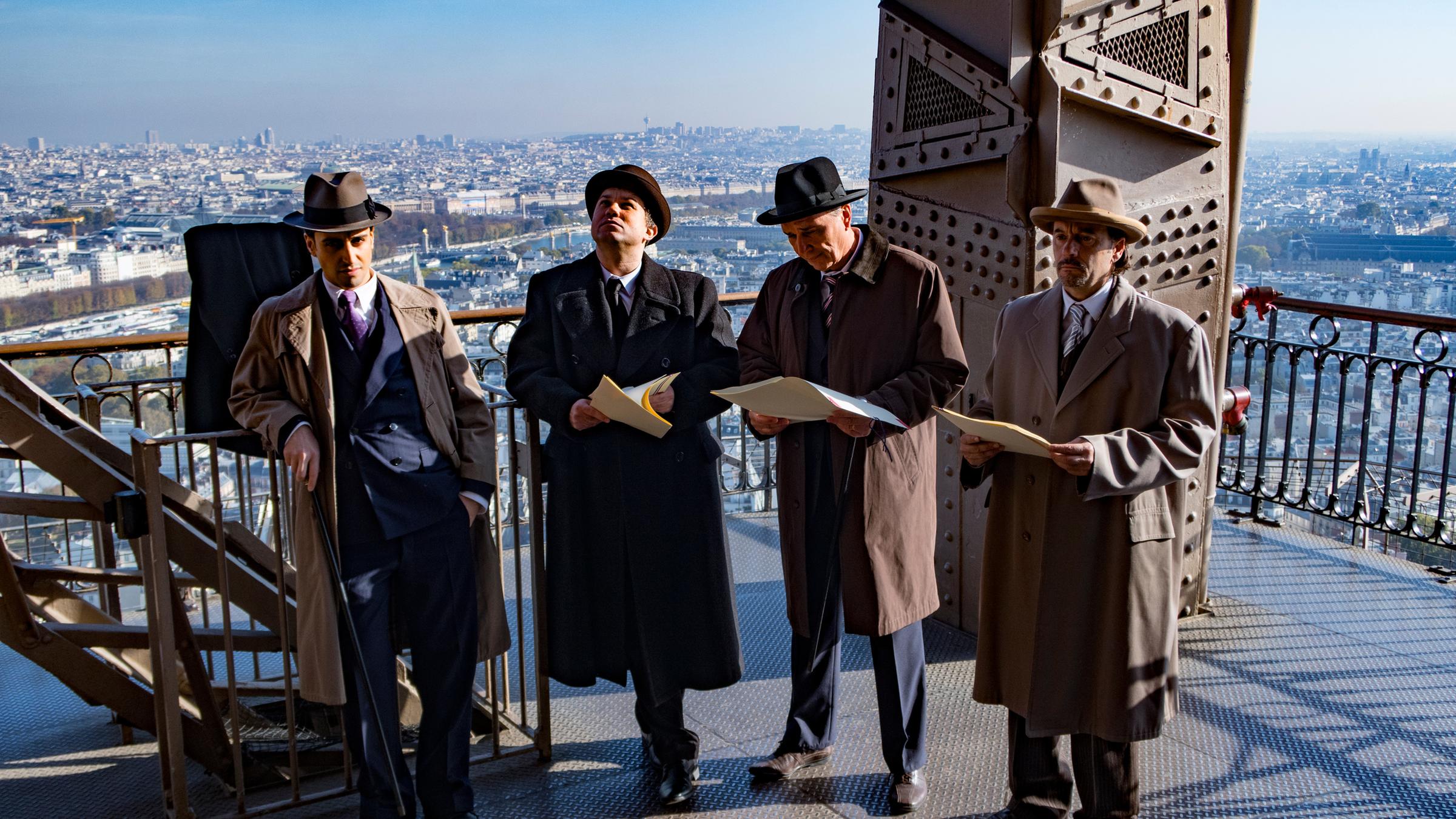 "Terra X: Der große Bluff - Meisterbetrüger der Geschichte": Victor Lustig (Loris Rizzo) und drei weitere Männer stehen auf der Plattform des Eiffelturms.