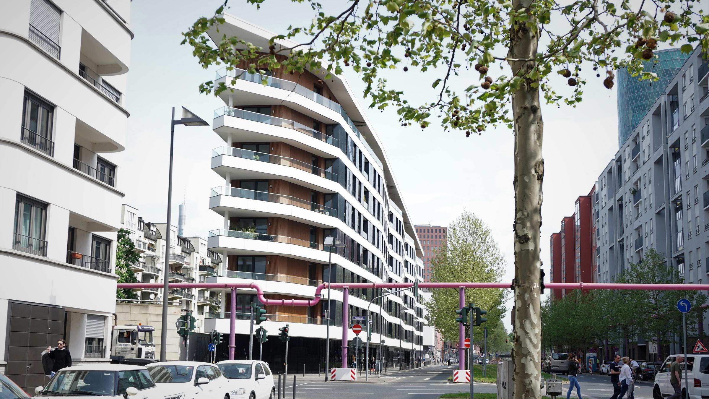 "planet e.: Planen, bauen, leben - Die Städte der Zukunft": Blick auf eine Straßenkreuzung in Frankfurt mit einem schmalen, modernen Gebäude.