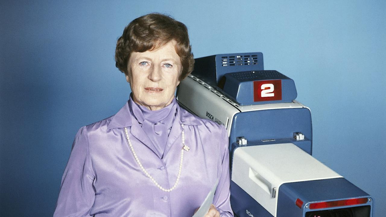 Fides Krause-Brewer steht neben einer Studiokamera im Studio