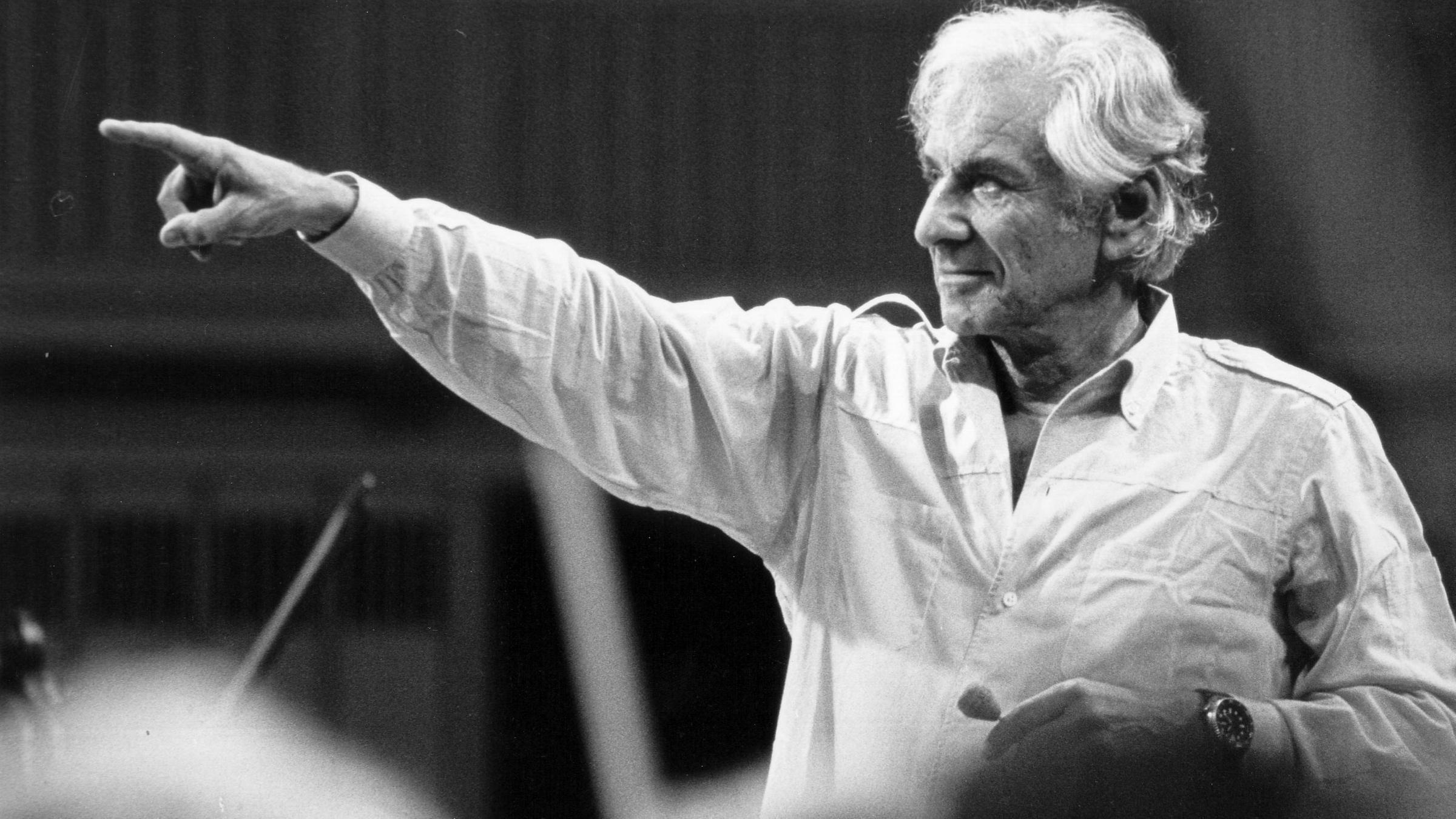 "Bernstein Story": Leonard Bernstein steht vor einem Orchester und zeigt mit dem Finger auf einen Musiker